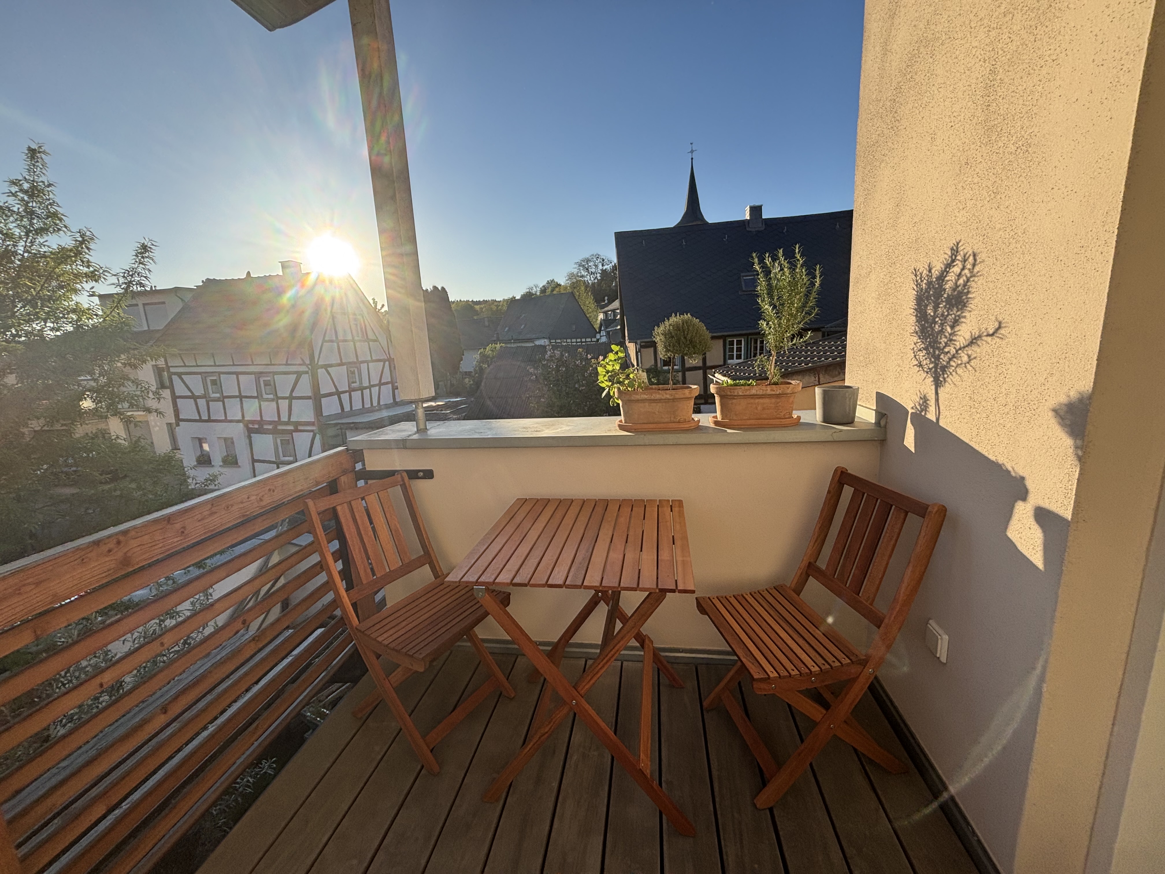 Sonniger Südbalkon mit Tisch und Stühlen